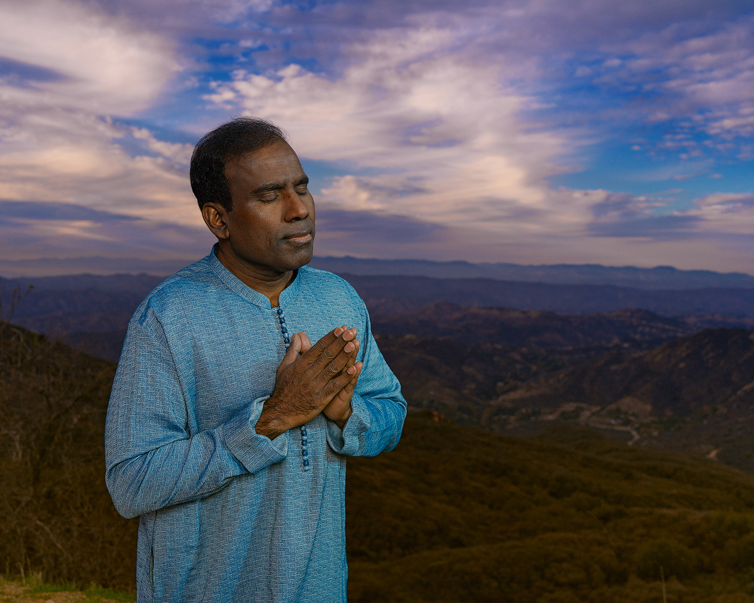 Dr. K.A. Paul praying on a mountain at dusk